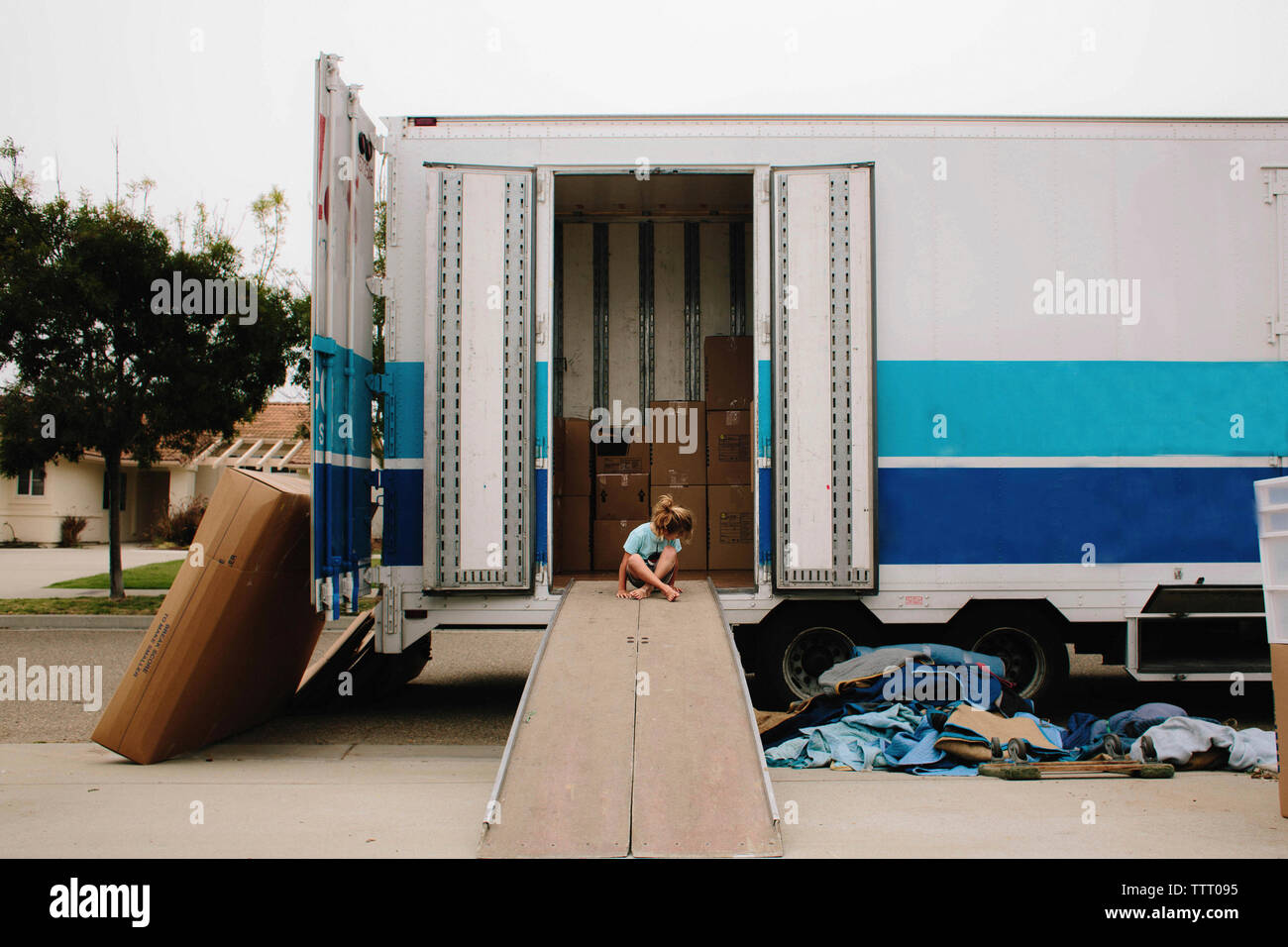 Girl sitting on plank de cargo truck Banque D'Images