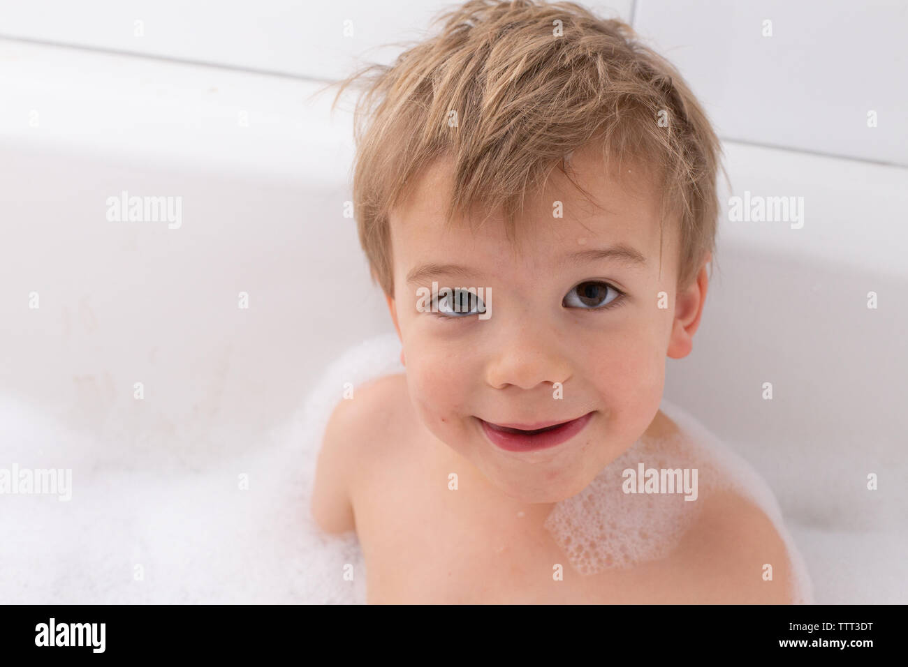 Enfant en prenant un bain moussant en blanc à remous Banque D'Images