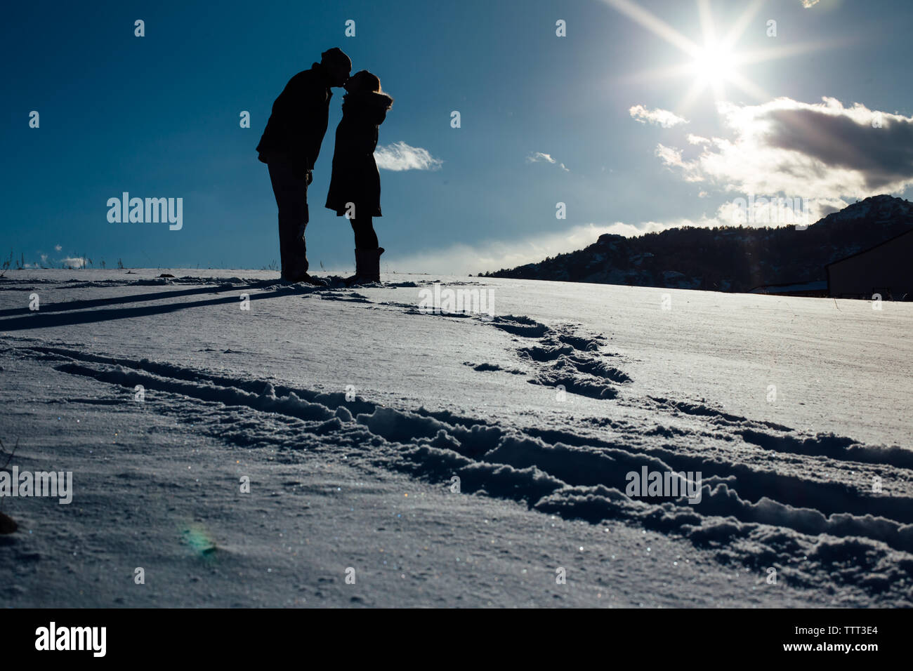 Couple dans la neige en face d'une montagne Banque D'Images