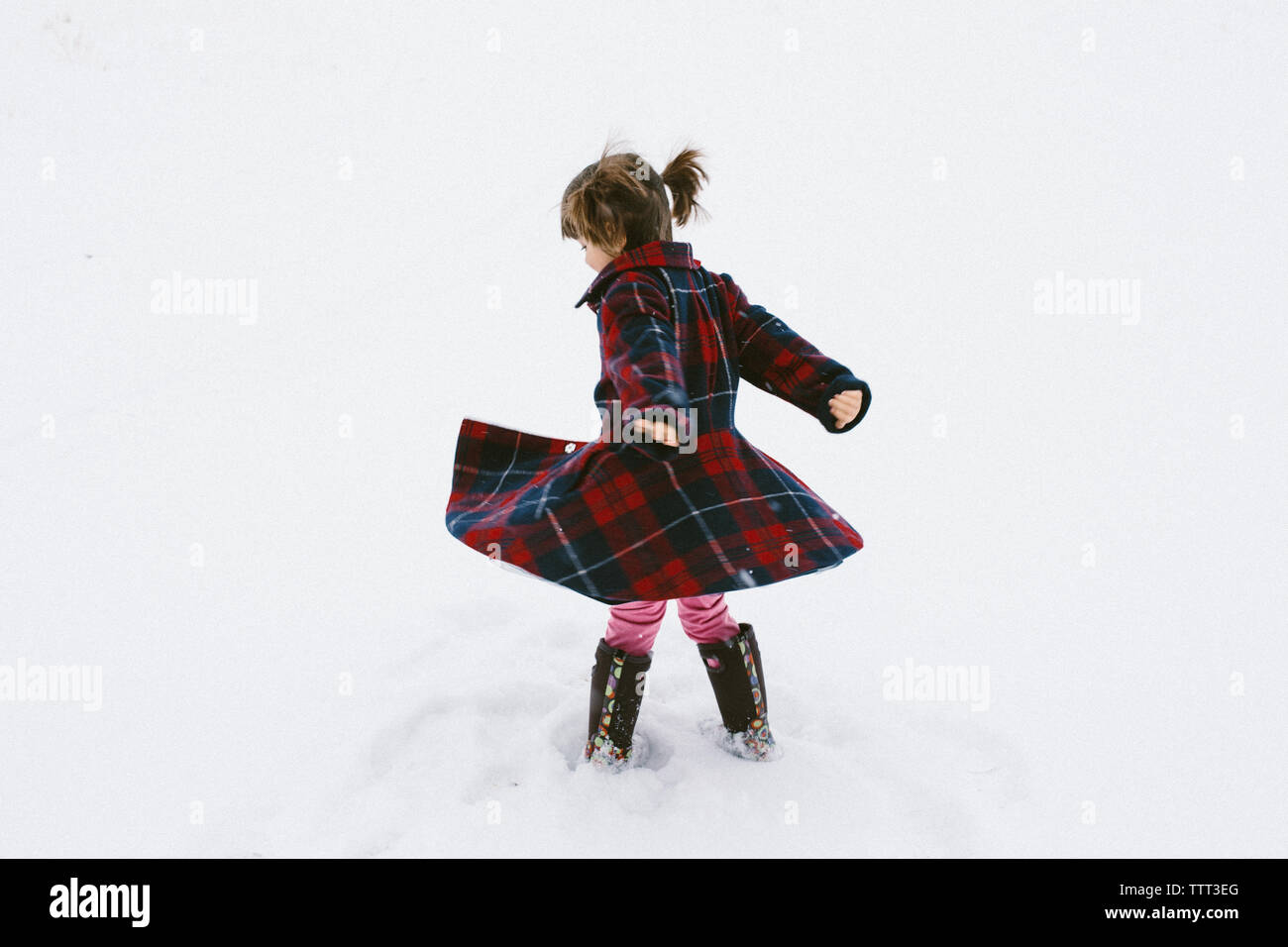 Girl spinning à faire tournoyer son manteau Banque D'Images