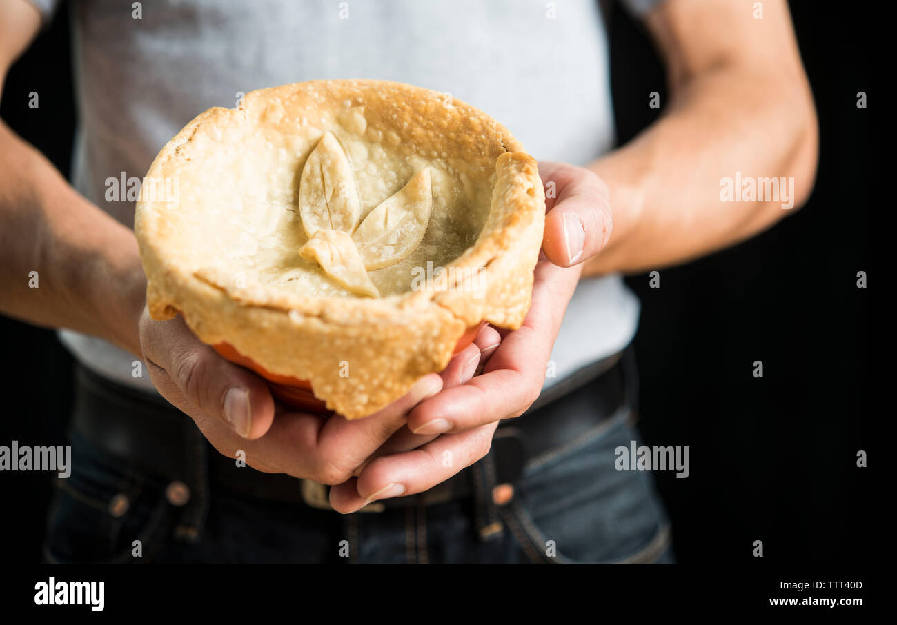 Portrait man holding Chicken Pot Pie sur fond noir Banque D'Images