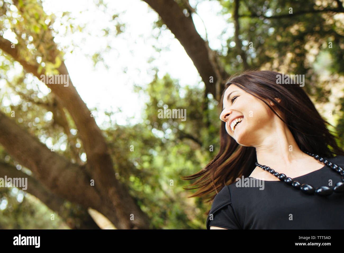 Close-up of cheerful woman tossing cheveux en forêt Banque D'Images