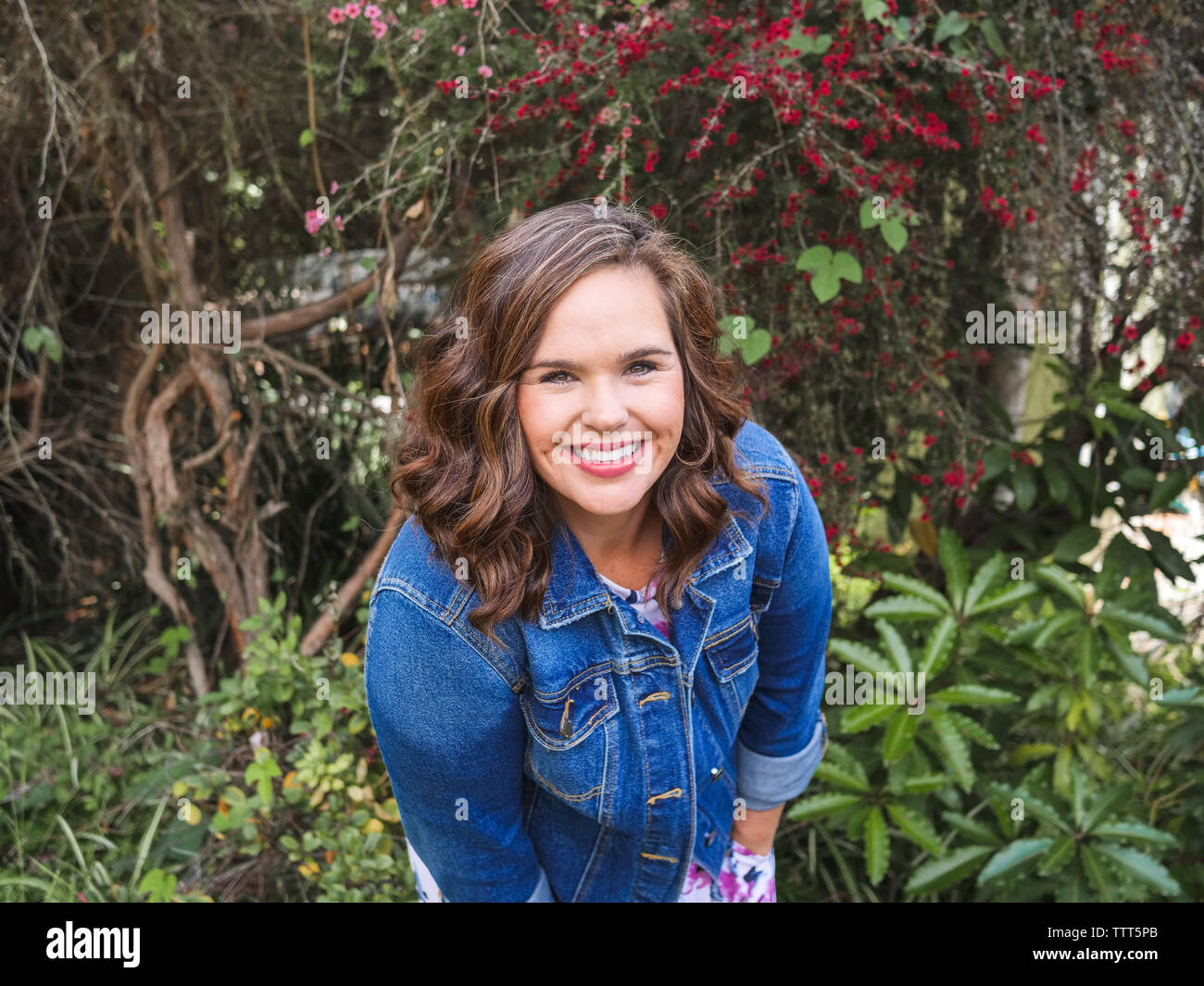 Portrait of a woman smiling tout en se penchant vers l'appareil photo Banque D'Images
