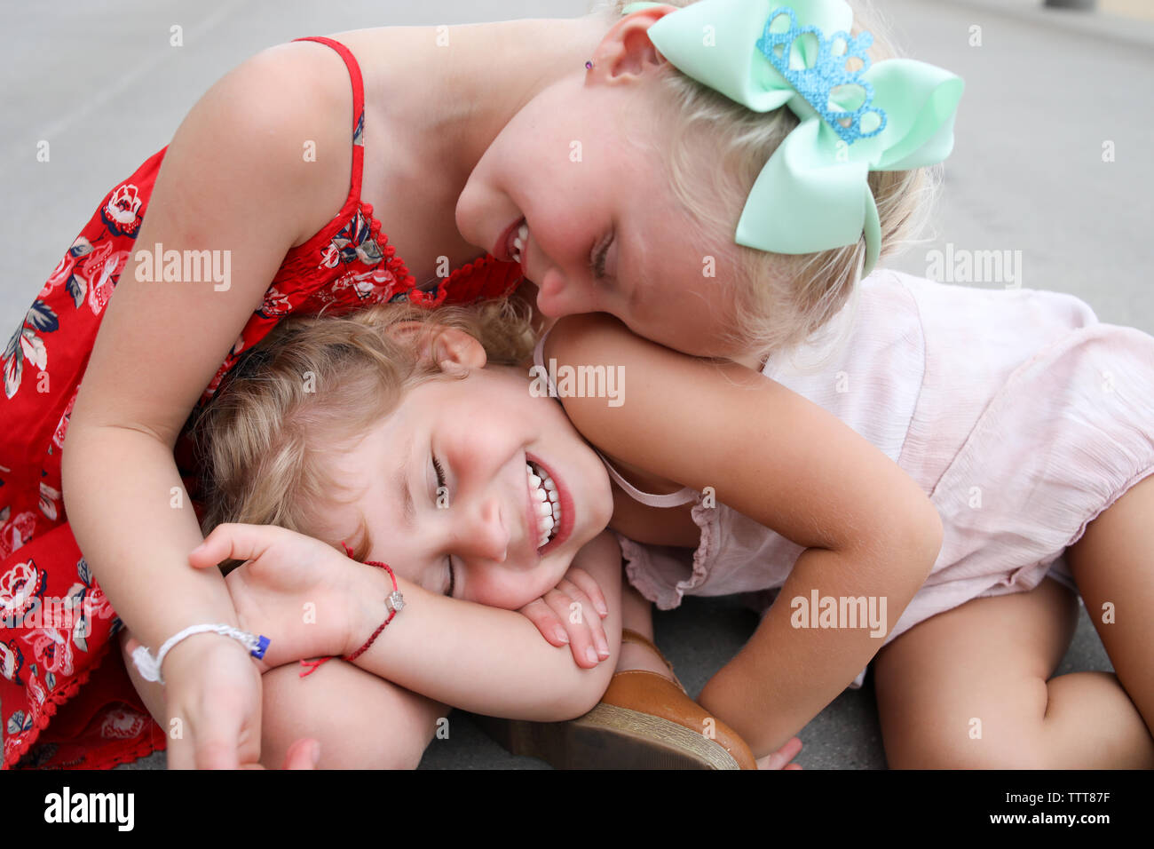 Les petites filles rire blotti ensemble sur boardwalk holding hands Banque D'Images