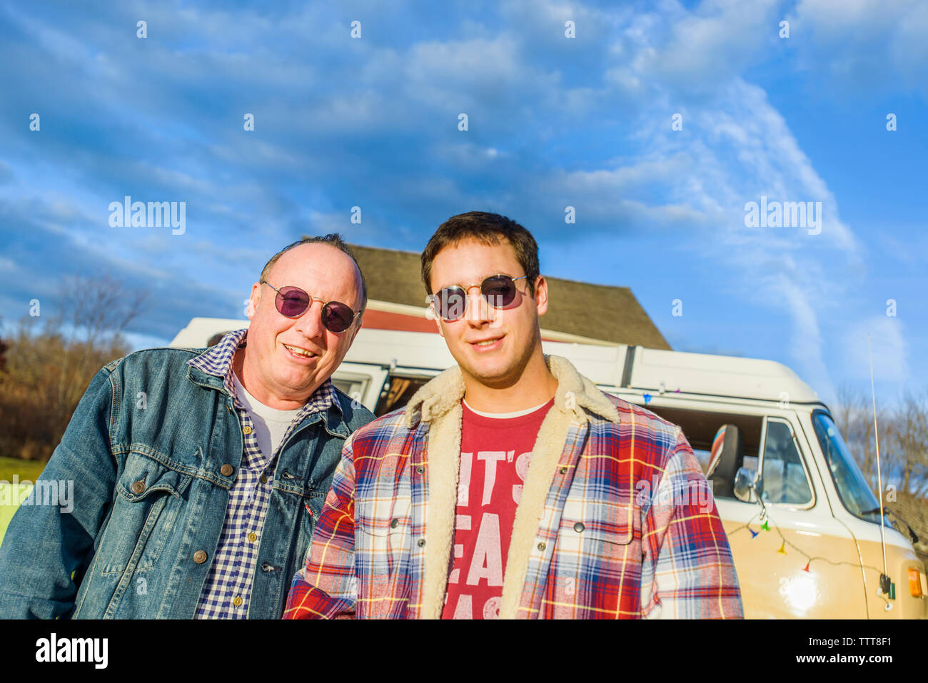 Portrait de père et fils debout contre le ciel bleu Banque D'Images