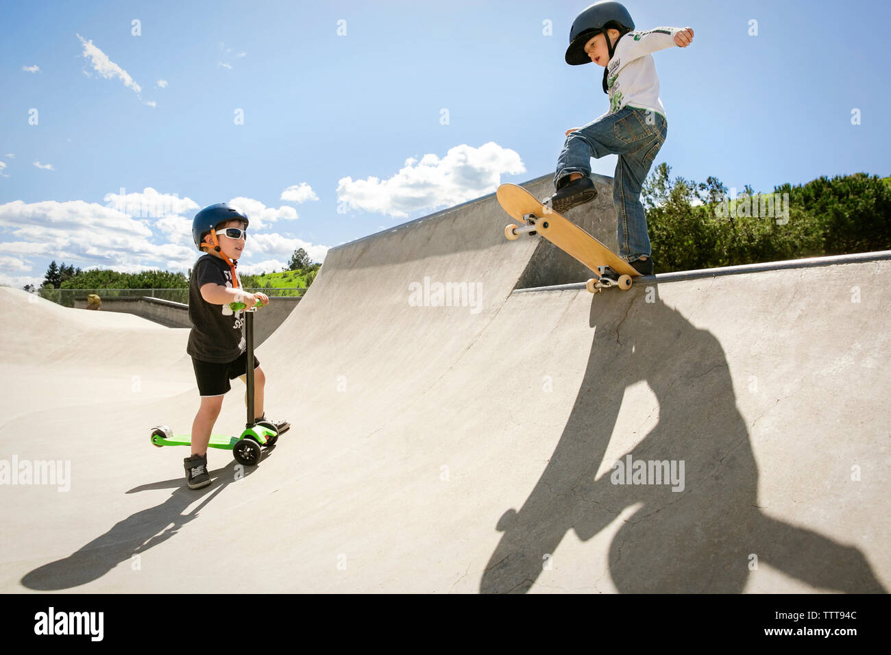 Boy looking at ami performing stunt sur rampe de planche à roulettes Banque D'Images