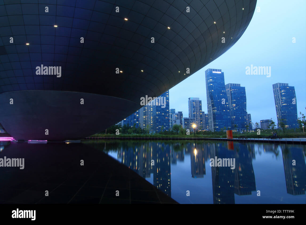 Conception Dongdaemun Plaza par reflecting pool contre ciel en ville au coucher du soleil Banque D'Images