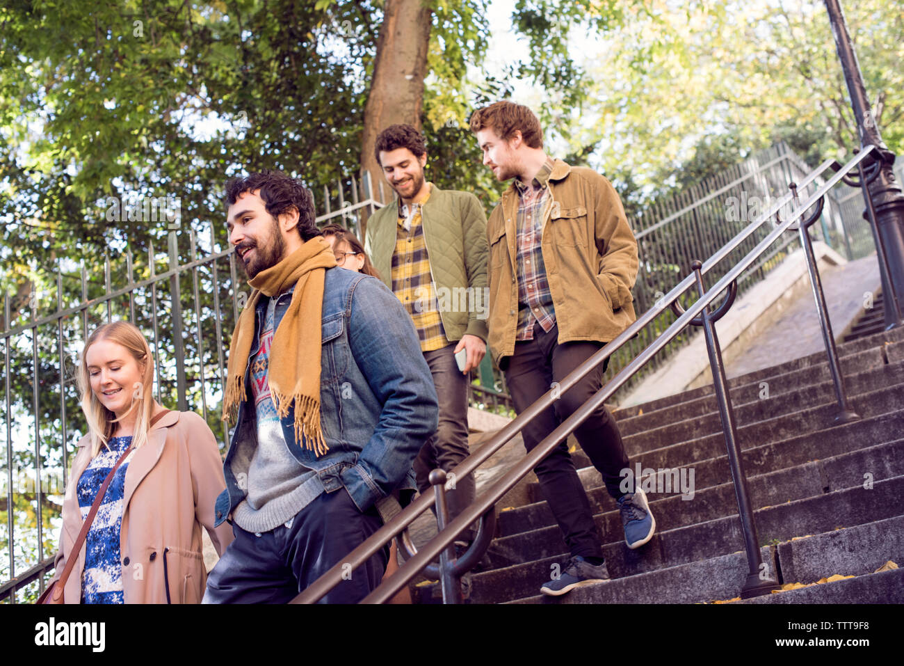 Happy friends moving down steps outdoors Banque D'Images