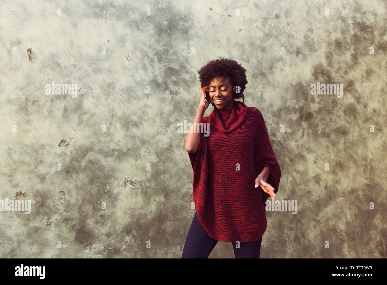 Happy woman against wall Banque D'Images