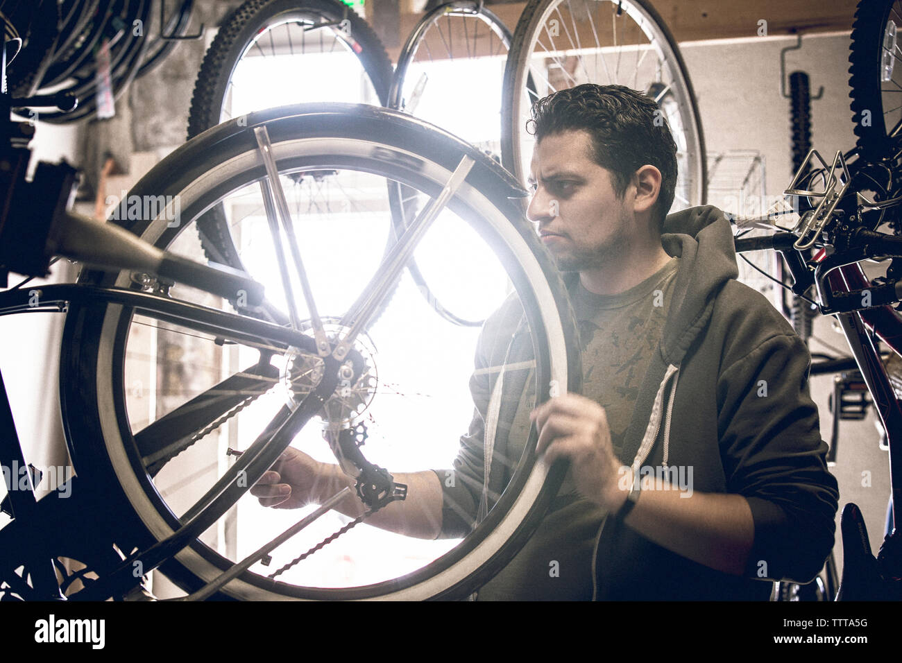 L'examen de la clientèle masculine des pneus de bicyclettes par store Banque D'Images