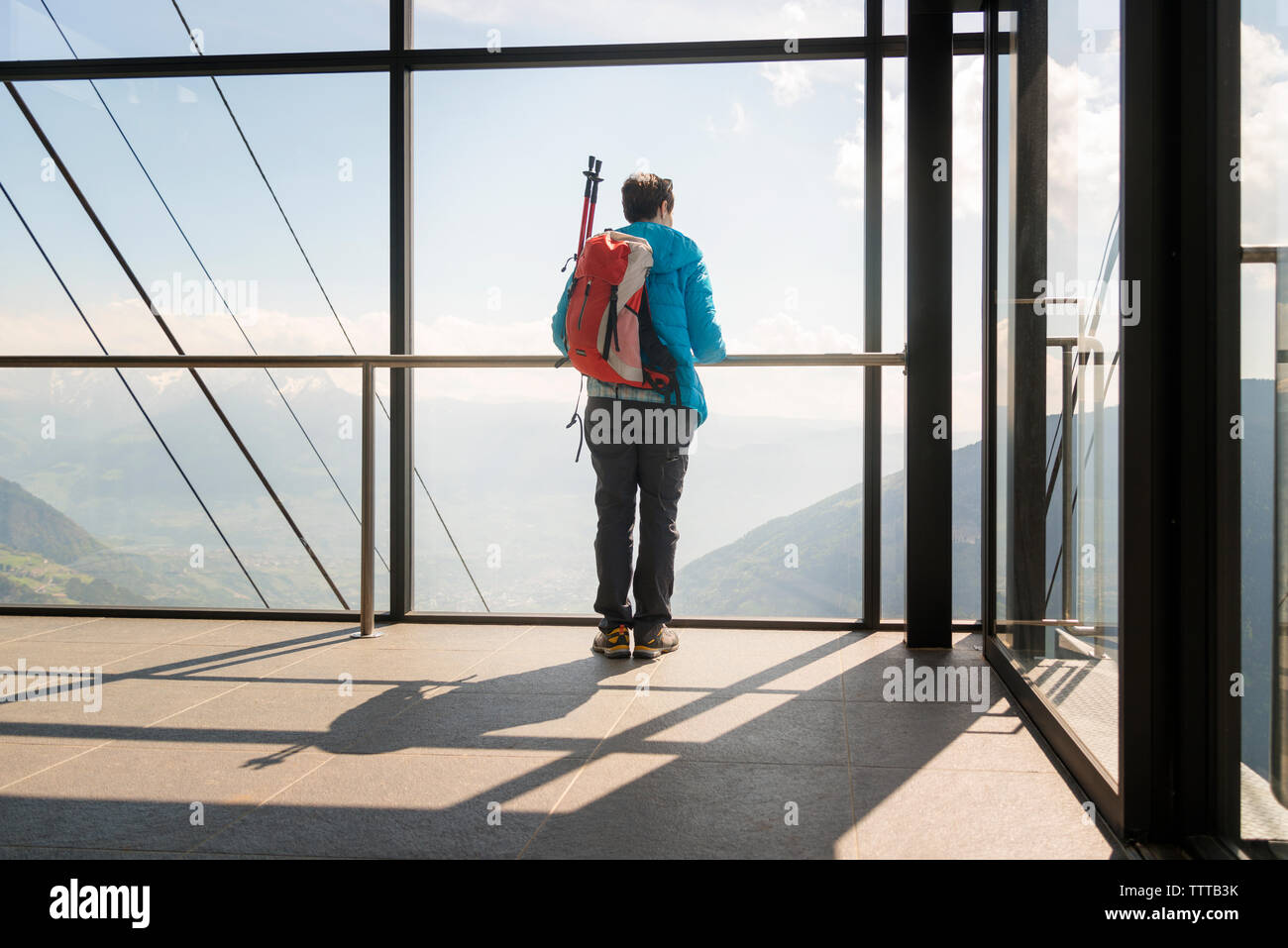 Vue arrière du female hiker à vue à travers la fenêtre à verre au point d'observation Banque D'Images