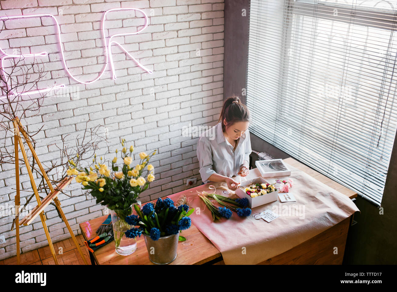 High angle view of woman working at table in flower shop Banque D'Images