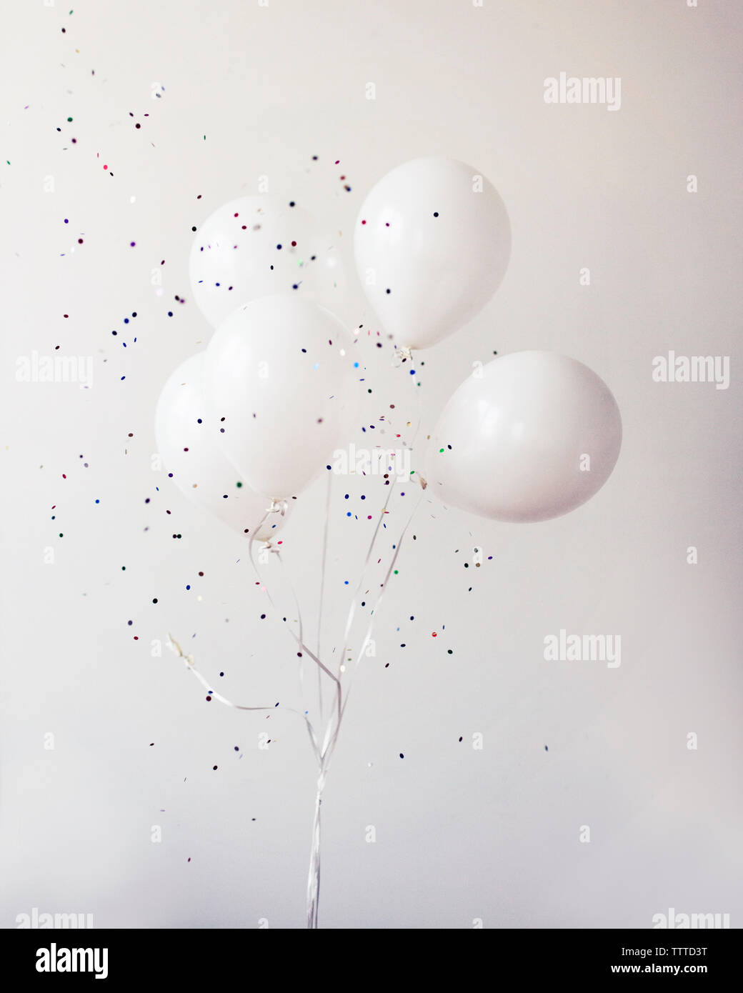 Ballons à l'hélium de confettis contre mur Banque D'Images