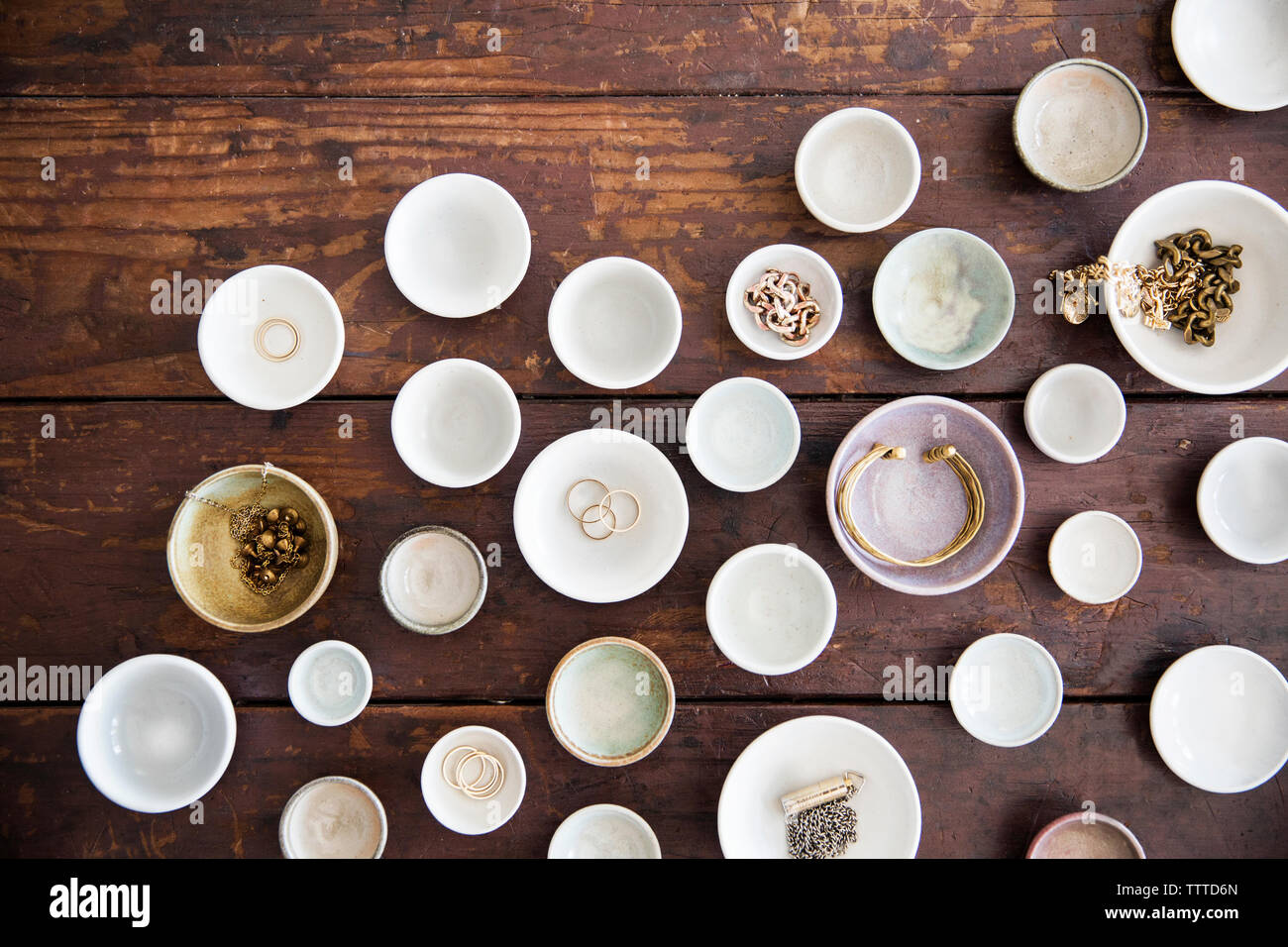Vue aérienne de bijoux dans des bols et assiettes disposées sur la table Banque D'Images