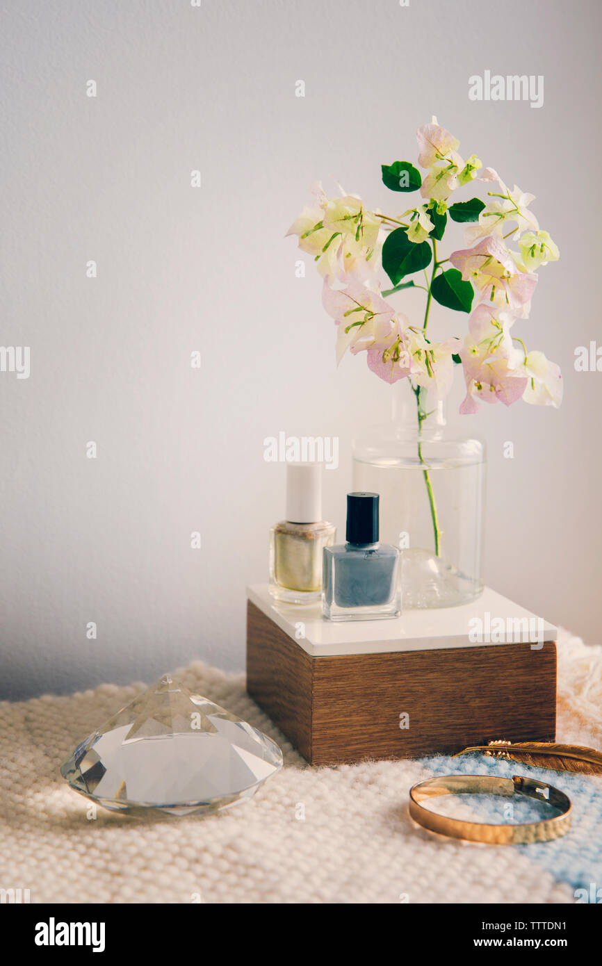 Vernis à ongles avec des bijoux en cristal et par vase à fleurs sur table Banque D'Images