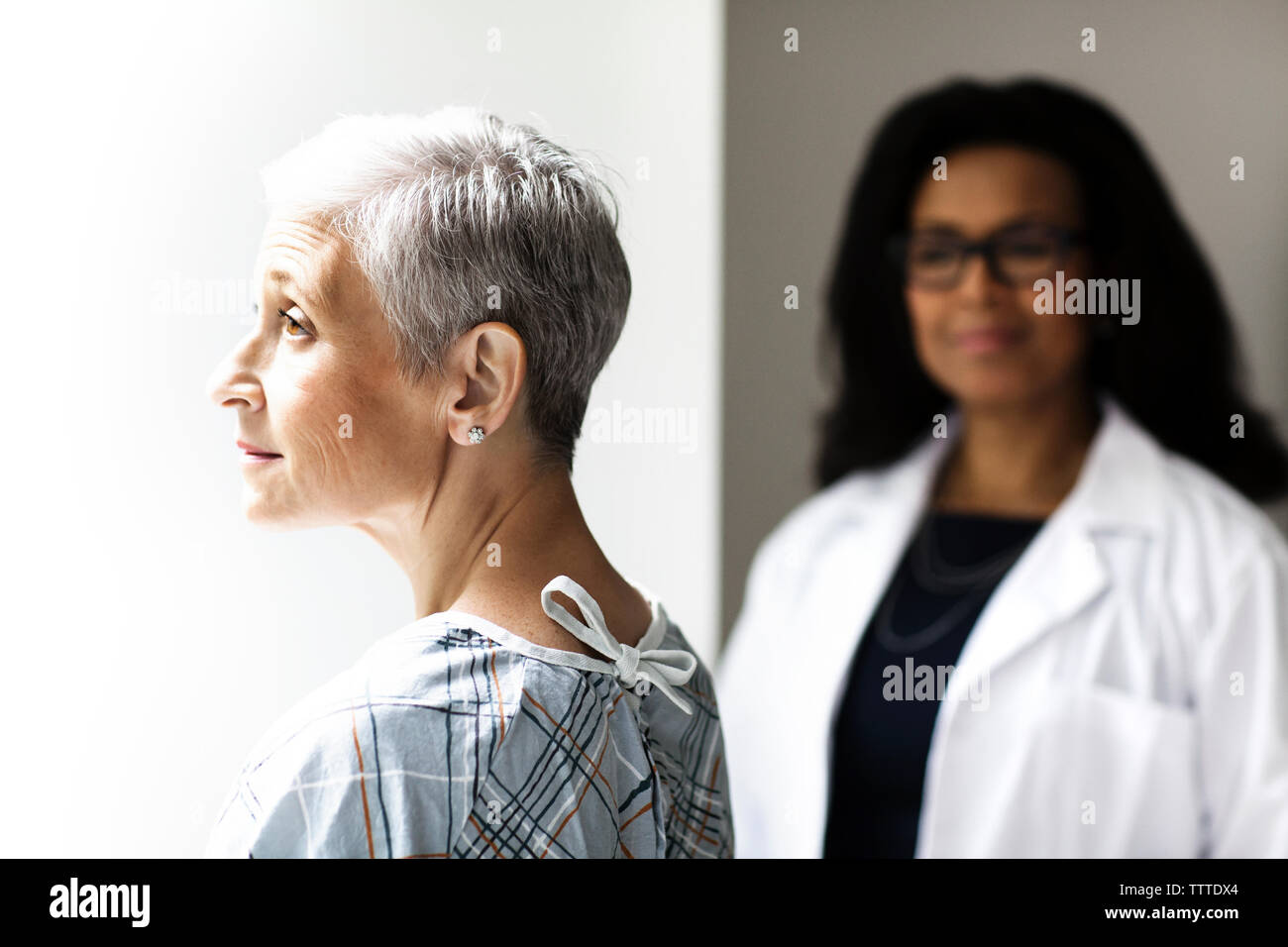 Femme sérieuse avec un médecin en arrière-plan Banque D'Images