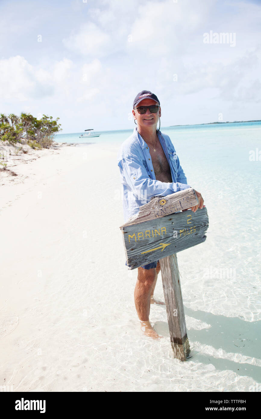 EXUMA, Bahamas. Yves, tenant une pancarte sur Boussole Cay. Banque D'Images