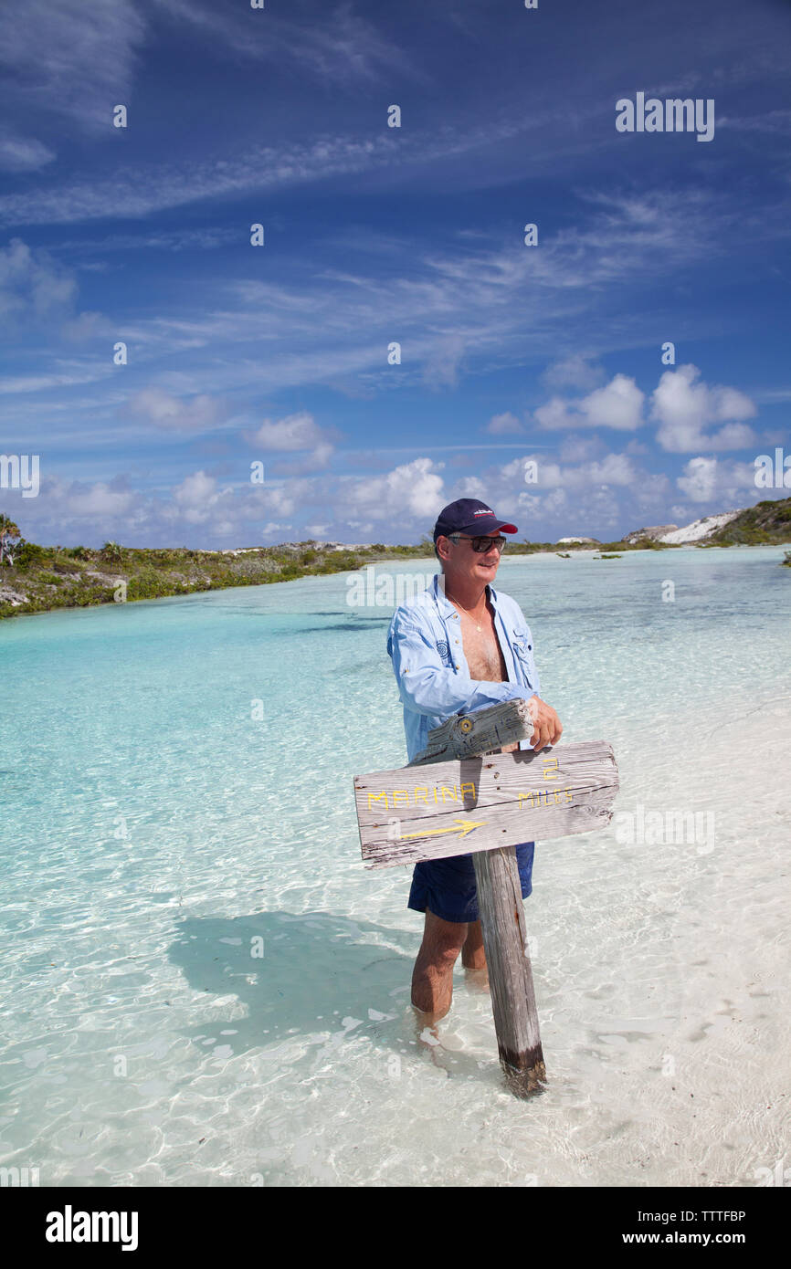 EXUMA, Bahamas. Yves, tenant une pancarte sur Boussole Cay. Banque D'Images
