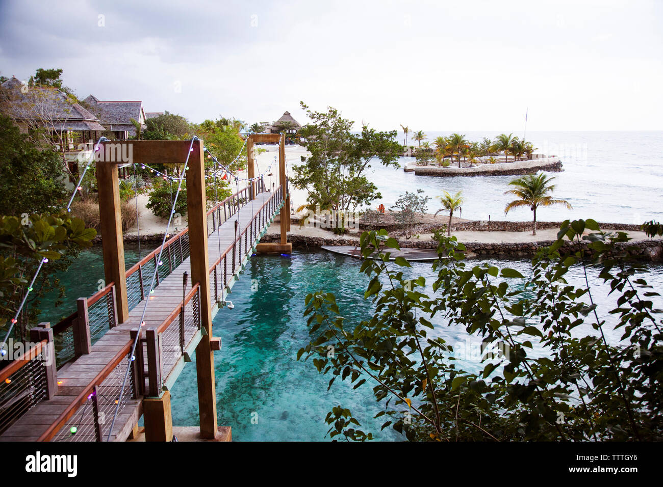 JAMAÏQUE, Oracabessa. GoldenEye Hotel and Resort. Vue sur le pont, la plage et les bungalows du complexe. Banque D'Images