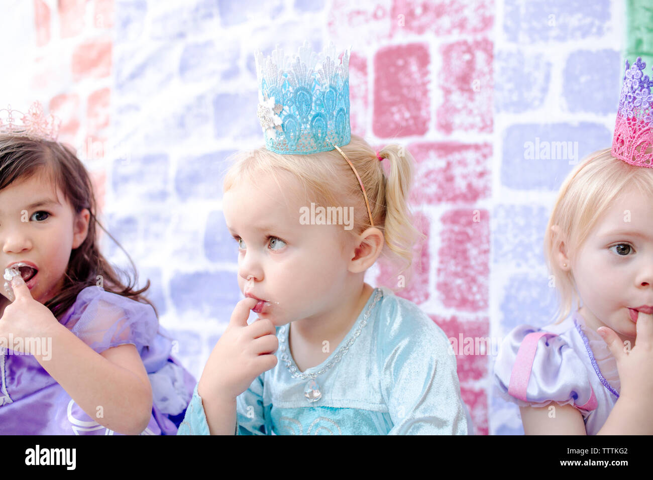 Close-up de filles avec les doigts dans la bouche au cours de peinture château assis contre la princesse partie Banque D'Images