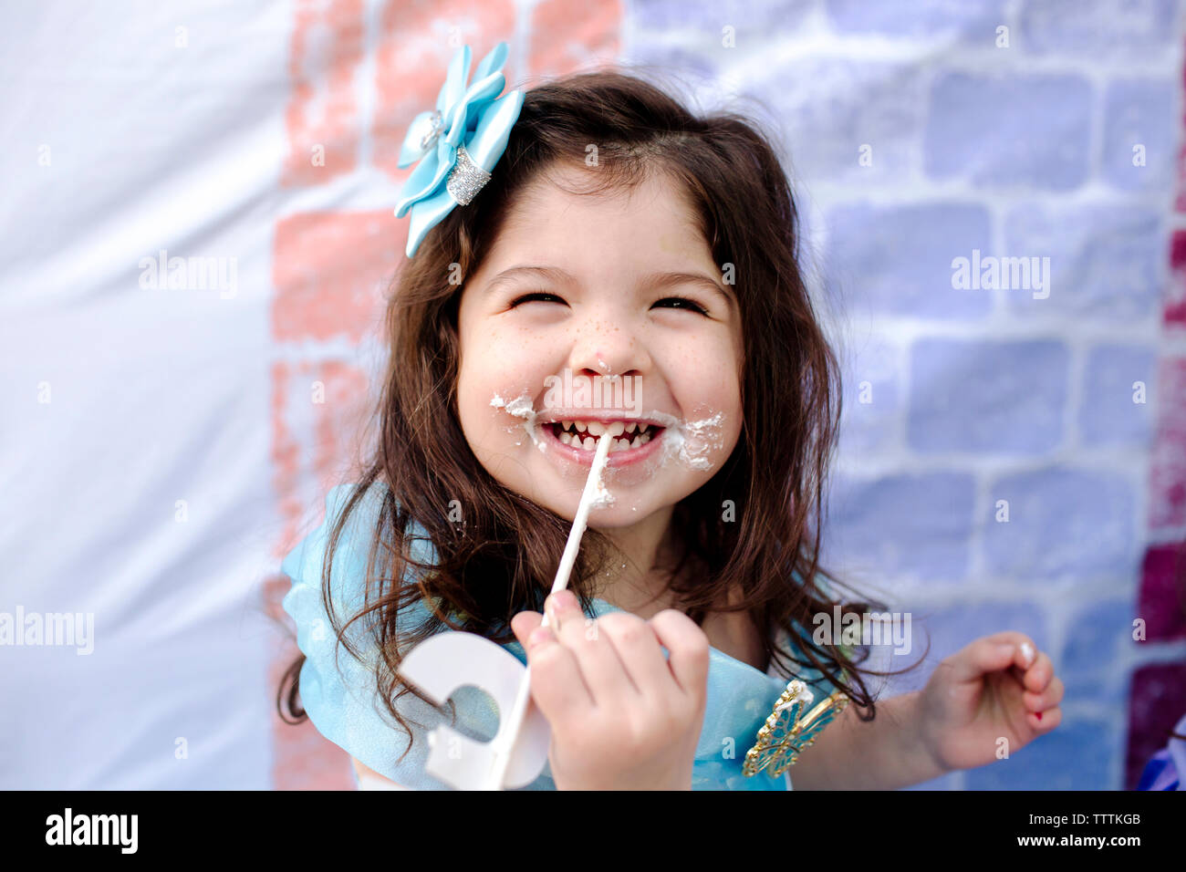 Close-up of cute smiling girl holding numéro 3 au cours de la princesse partie Banque D'Images