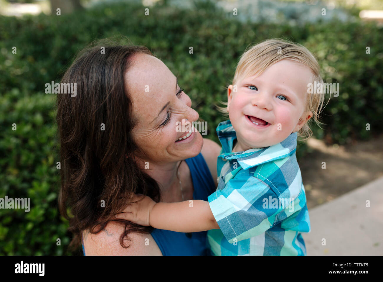 High angle portrait of cheerful baby boy avec happy woman at park Banque D'Images