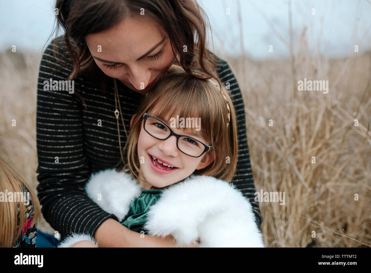 Close-up of mother with daughter sitting on grassy field Banque D'Images