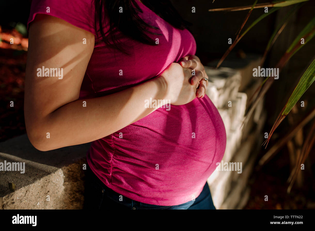 Portrait de femme enceinte se tenant à cour Banque D'Images