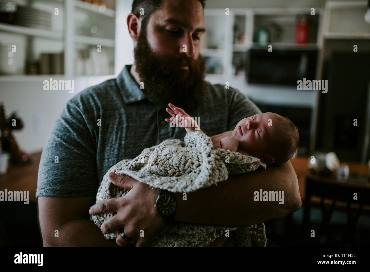 Père barbu transportant mignon fille à dormir debout à la maison Banque D'Images