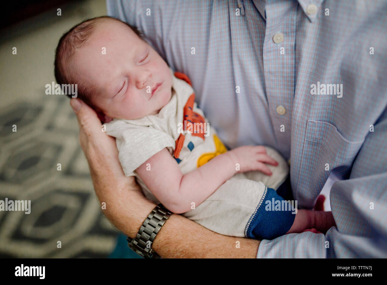 Portrait père exerçant son mignon nouveau-né fils de couchage à la maison Banque D'Images