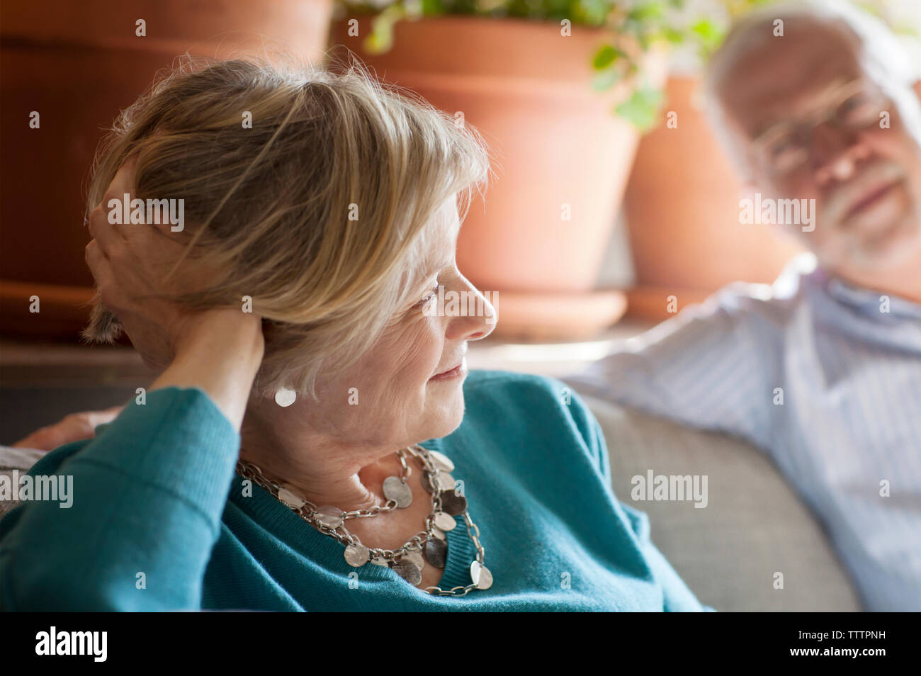 Senior couple sitting on sofa at home Banque D'Images
