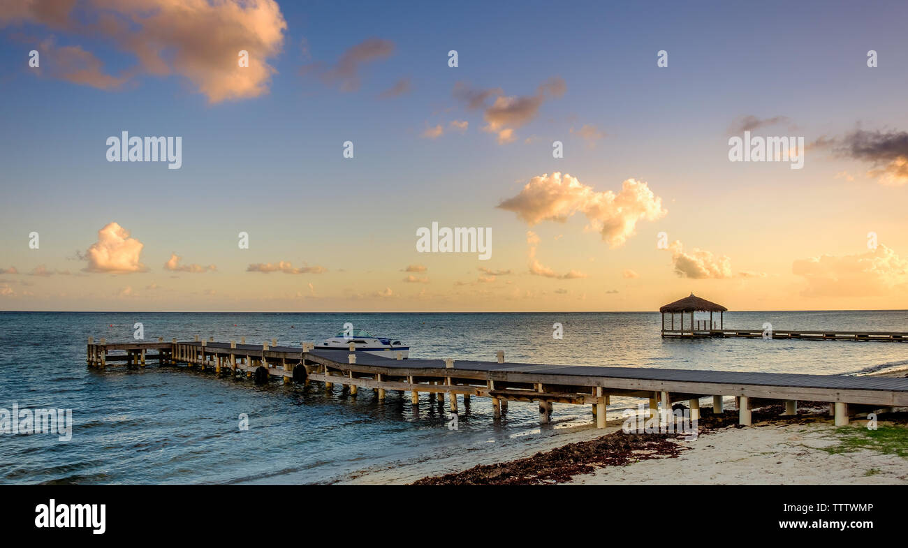 Piers au coucher du soleil sur la mer des Caraïbes, dans la région du Sud, Grand Cayman, Cayman Islands Banque D'Images
