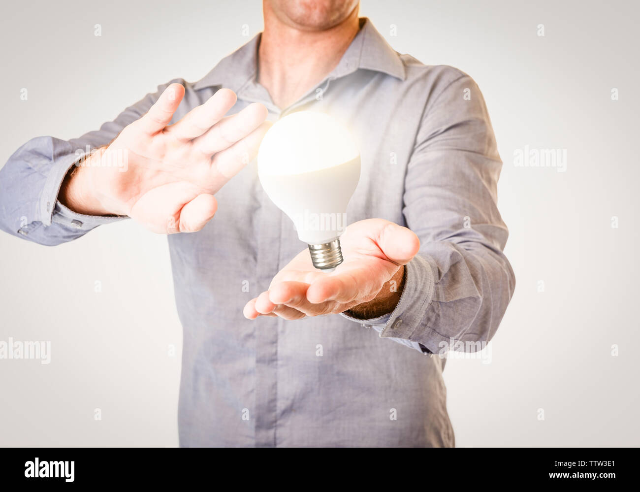 Habillé décontracté businessman with floating lightbulb éclat clair au-dessus de sa main. Idée d'entreprise concept image avec copie espace pour le texte. Banque D'Images