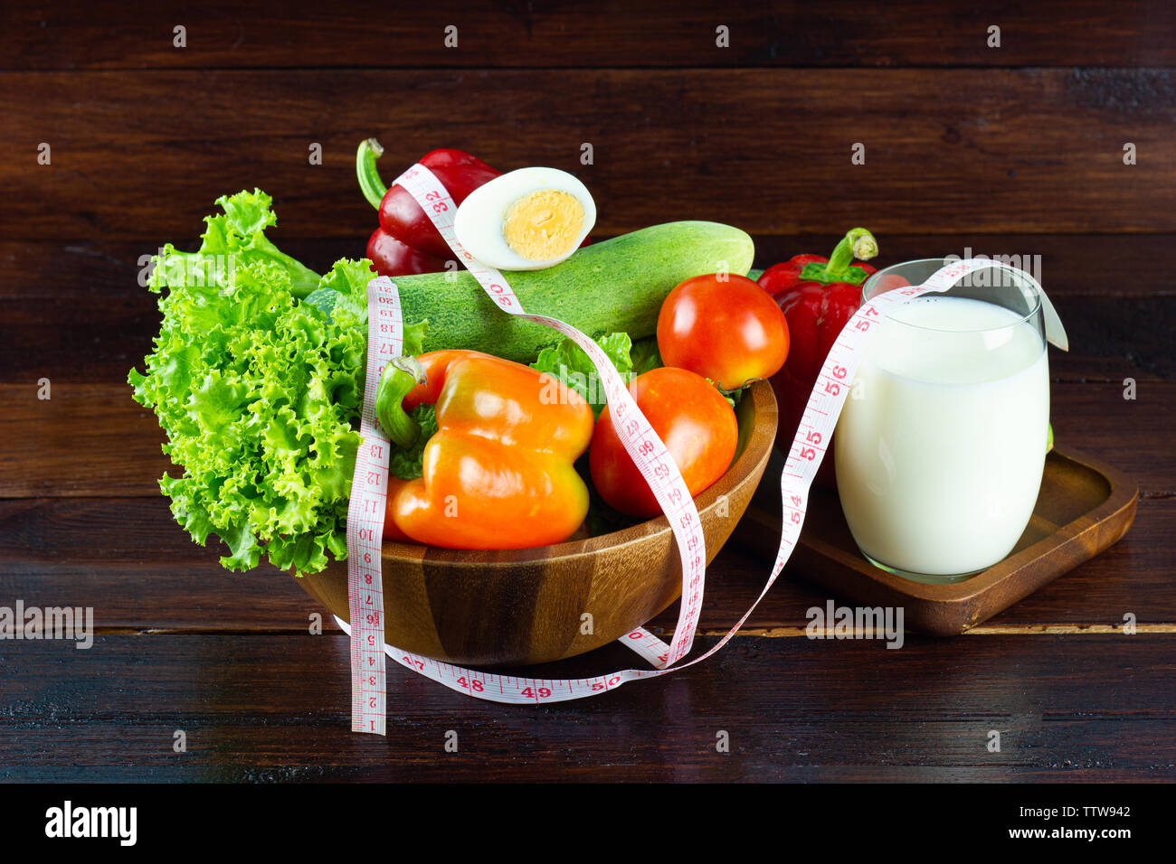 Une salade verte à la coupe du bois composé d'un mélange de petits légumes verts à feuilles généralement, différentes sortes de légumes avec du lait dans un verre concept Goo Banque D'Images