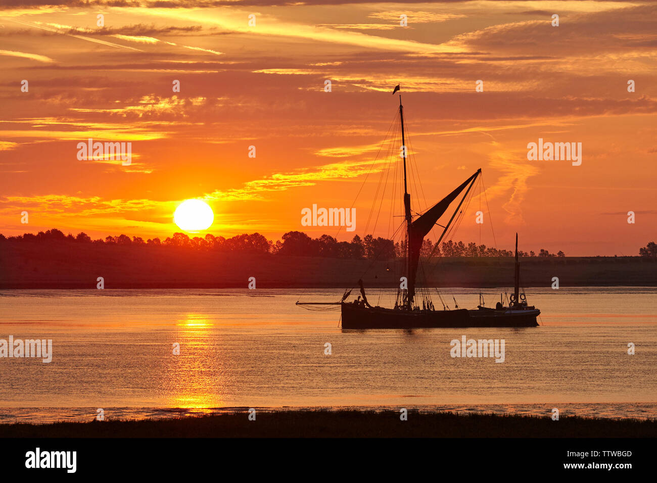 L'estuaire de Swale, Kent, UK. 18 Juin 2019 : la météo. Lever du soleil sur la vieille barge à Thames Vfd Holding, amarrés dans la rigole de l'estuaire. Comme le solstice d'été est approché le temps est défini pour être ensoleillé avec quelques averses. Credit : Alan Payton/Alamy Live News Banque D'Images