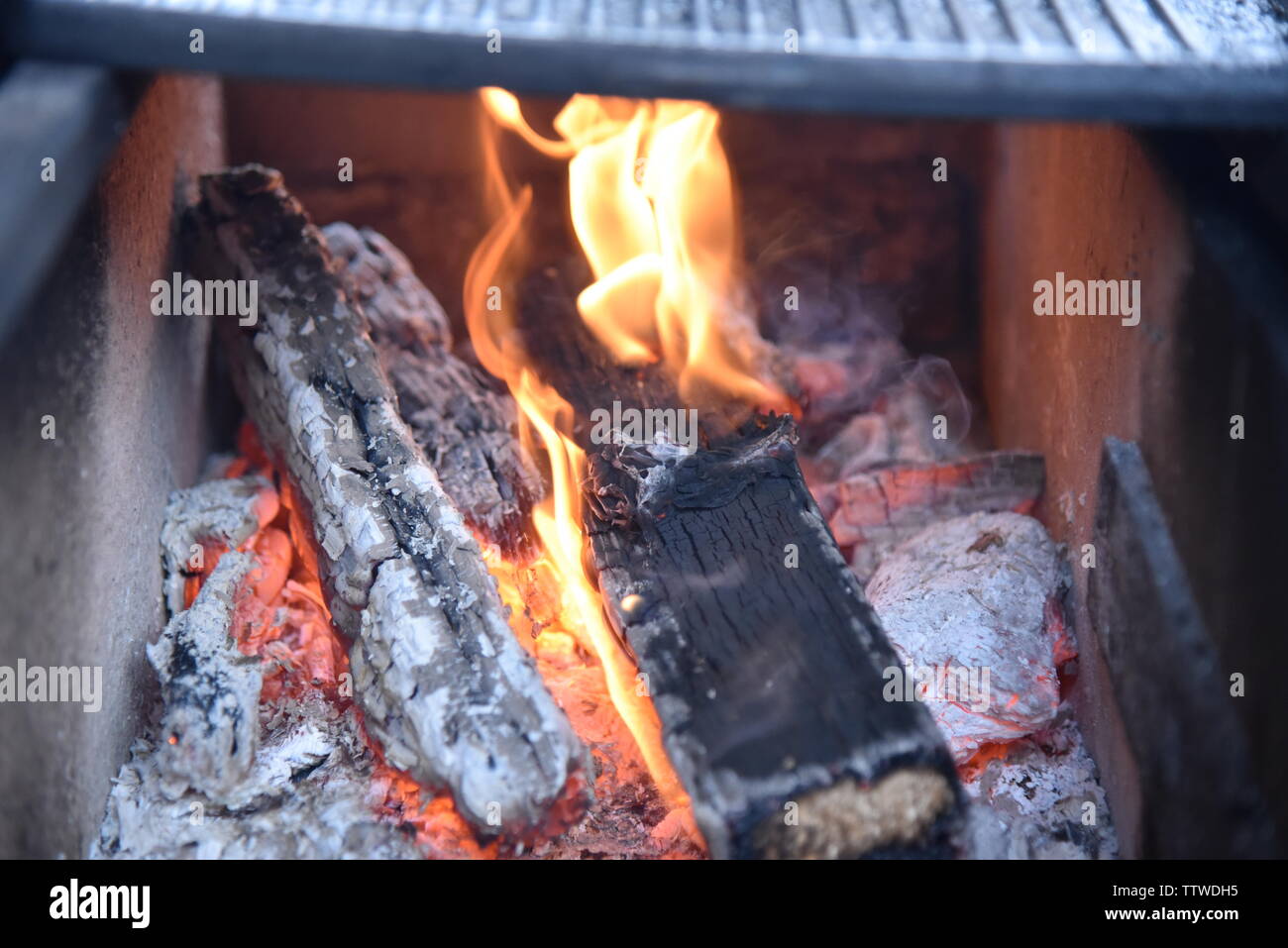 La legna arde sotto la piastra in ghisa... Banque D'Images
