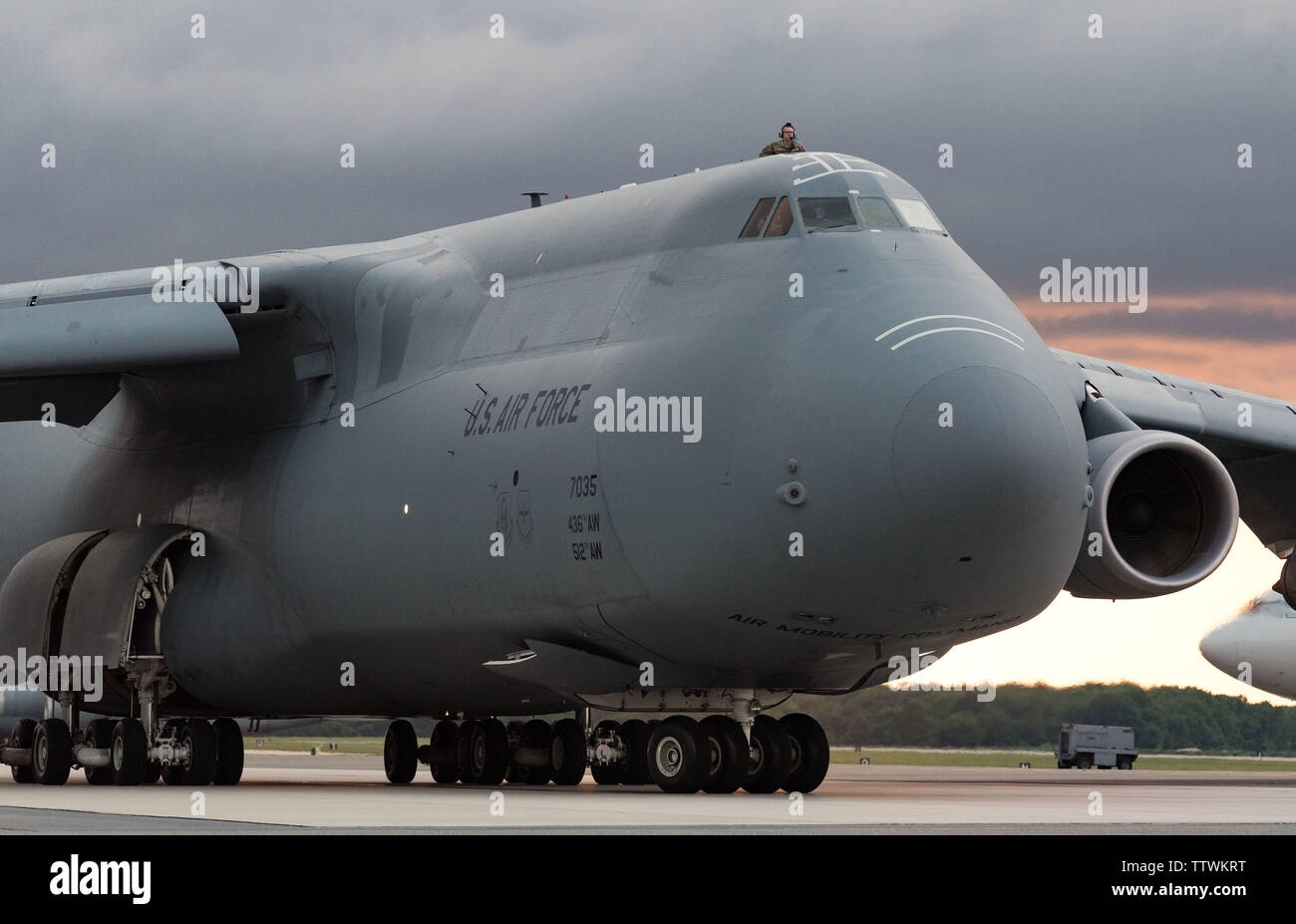 Un C-5M Super Galaxy membre de l'équipage donne le nombre 1 trappe d'évacuation de l'appareil pendant que les taxis en bas de la ligne de vol avant le décollage le 13 juin 2019 à Dover Air Force Base, Del. Le Super Galaxie a décollé comme un orage s'est approché la base. Il y a 18 C-5ms sont affectés à Douvres. (U.S. Air Force photo de Roland Balik) Banque D'Images