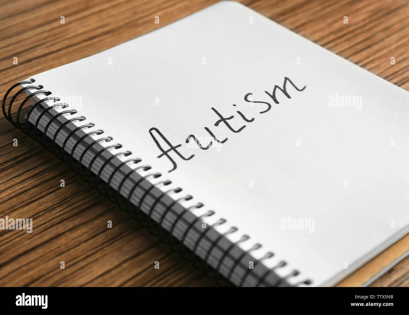 Autisme mot écrit en portable sur fond de bois, gros plan Banque D'Images