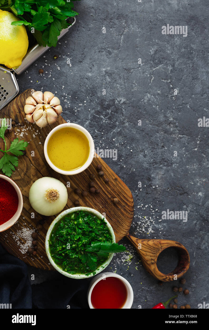 Restaurant menu concept. Ingrédients pour la cuisson ou Chimichurri vert argentin salsa ou bavette sauce sur pierre sombre contexte Vue d'en haut Banque D'Images