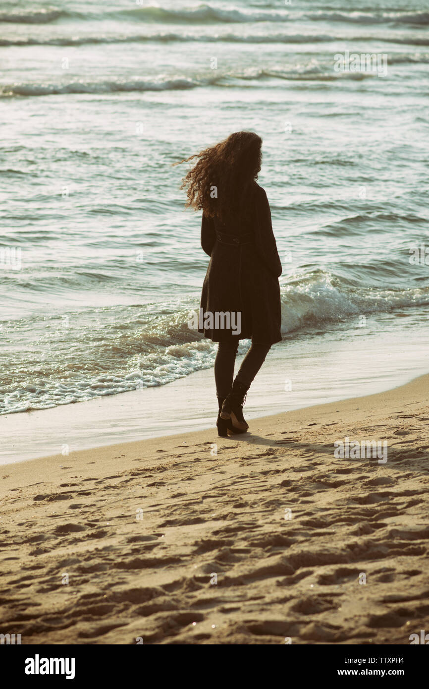 Jeune femme marche sur la plage Banque D'Images