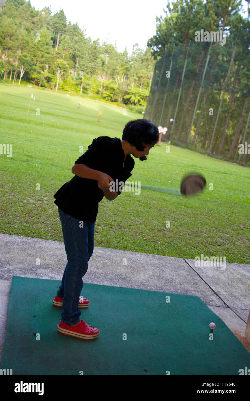 Fille pratiquant le golf à l'aire d'échauffement Banque D'Images