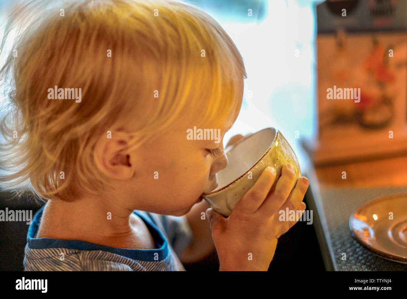 Petit garçon à boire le thé dans le restaurant Banque D'Images