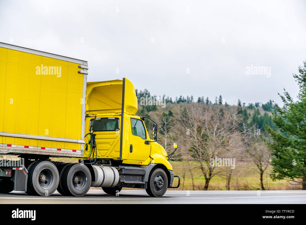 Gros camion jaune vif semi cabine jour camion pour les livraisons locales avec becquet aérodynamique sur le toit le transport sec jaune van semi-remorque sur le roa Banque D'Images