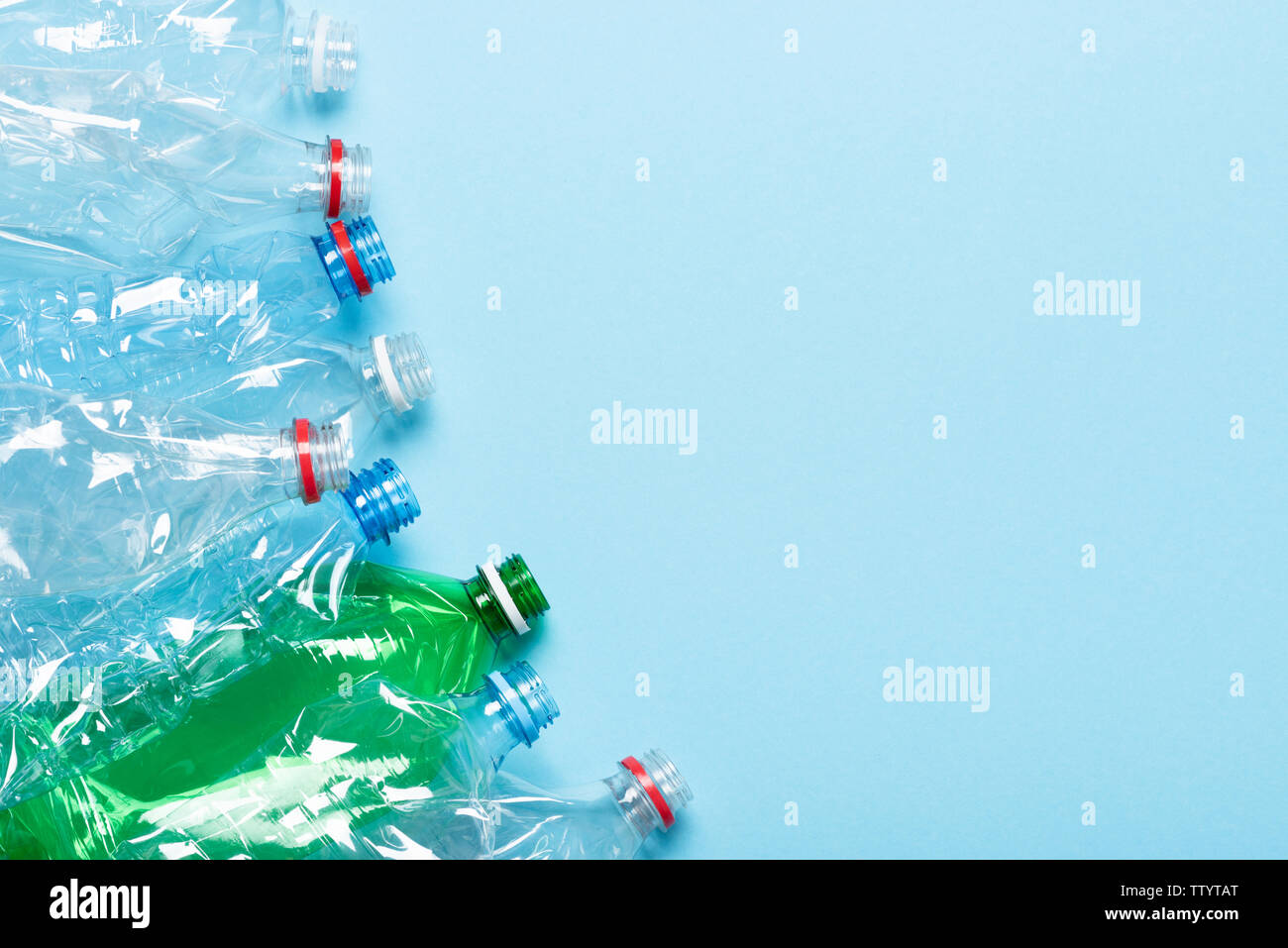 Les bouteilles en plastique sur fond bleu vue d'en haut. Recycler les déchets plastiques concept frontière avec la pollution de l'espace de copie. Banque D'Images