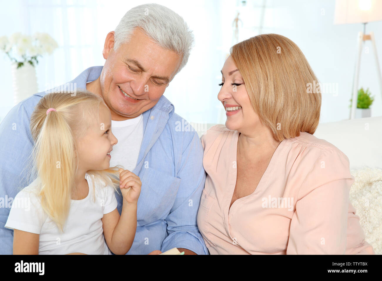 Happy cute girl avec les grands-parents dans la salle de séjour Banque D'Images