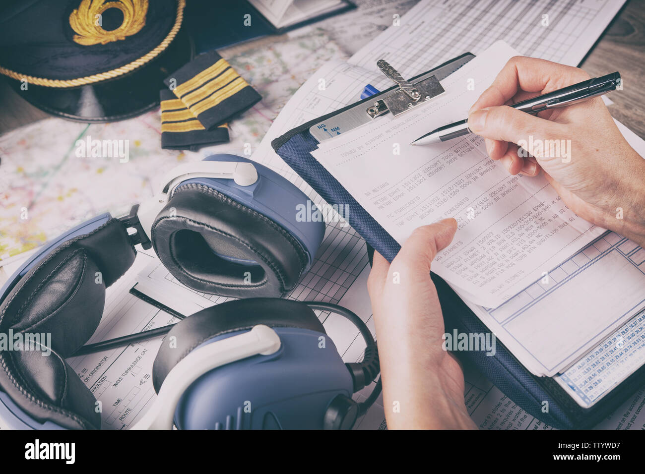 Portrait d'un pilote d'avion part remplir une liste de vérification pré-vol en helicoptère et holding météo avec de l'équipement y compris hat, épaulettes et autres d Banque D'Images