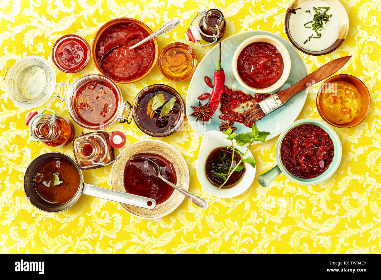 Mise à plat d'assortiment de couleur rouge et blanc à l'intérieur de sauce sauces bols sur le haut de la surface jaune à motifs Banque D'Images