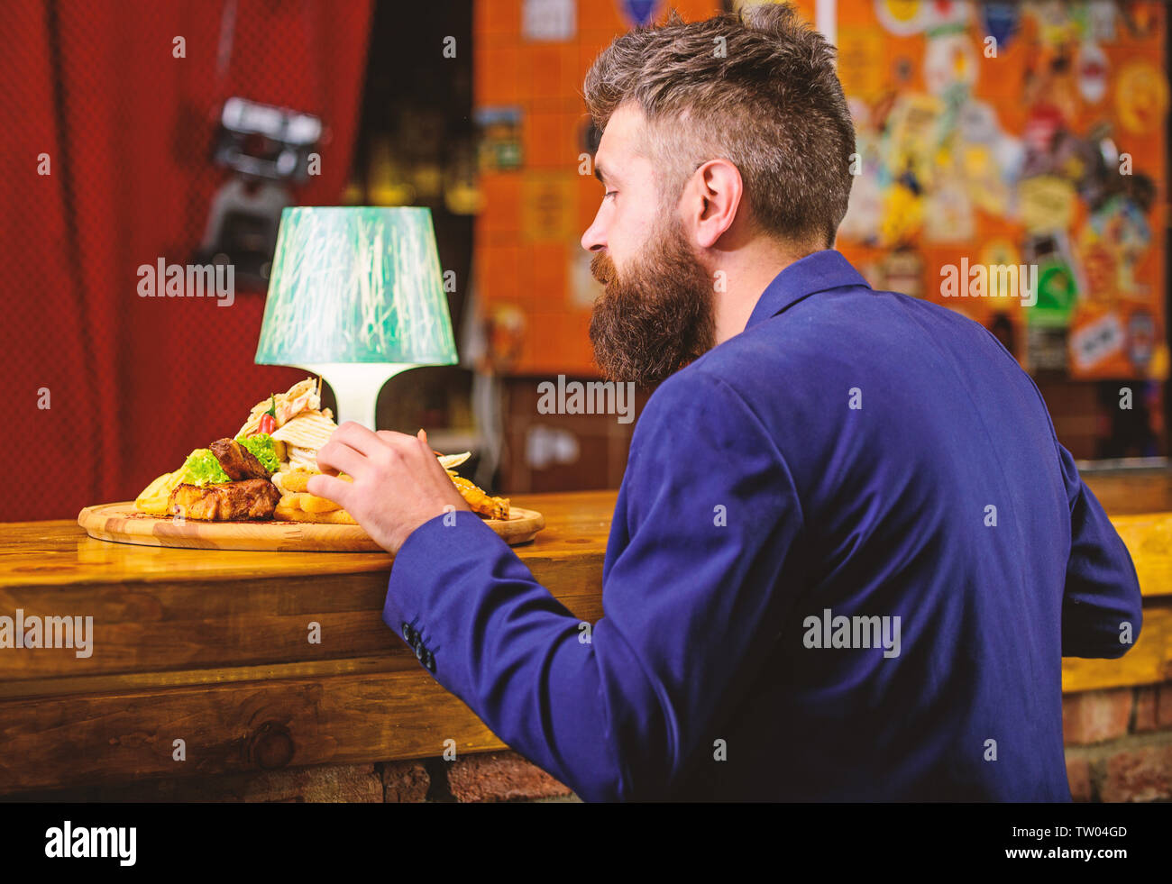 Profitez de repas. Restaurant client. Costume officiel Hipster s'asseoir au comptoir du bar. L'homme a reçu de pommes de terre frites repas avec les bâtonnets de poisson viande. Délicieux repas. Tricher repas. Hipster faim manger pub aliments frits. Banque D'Images
