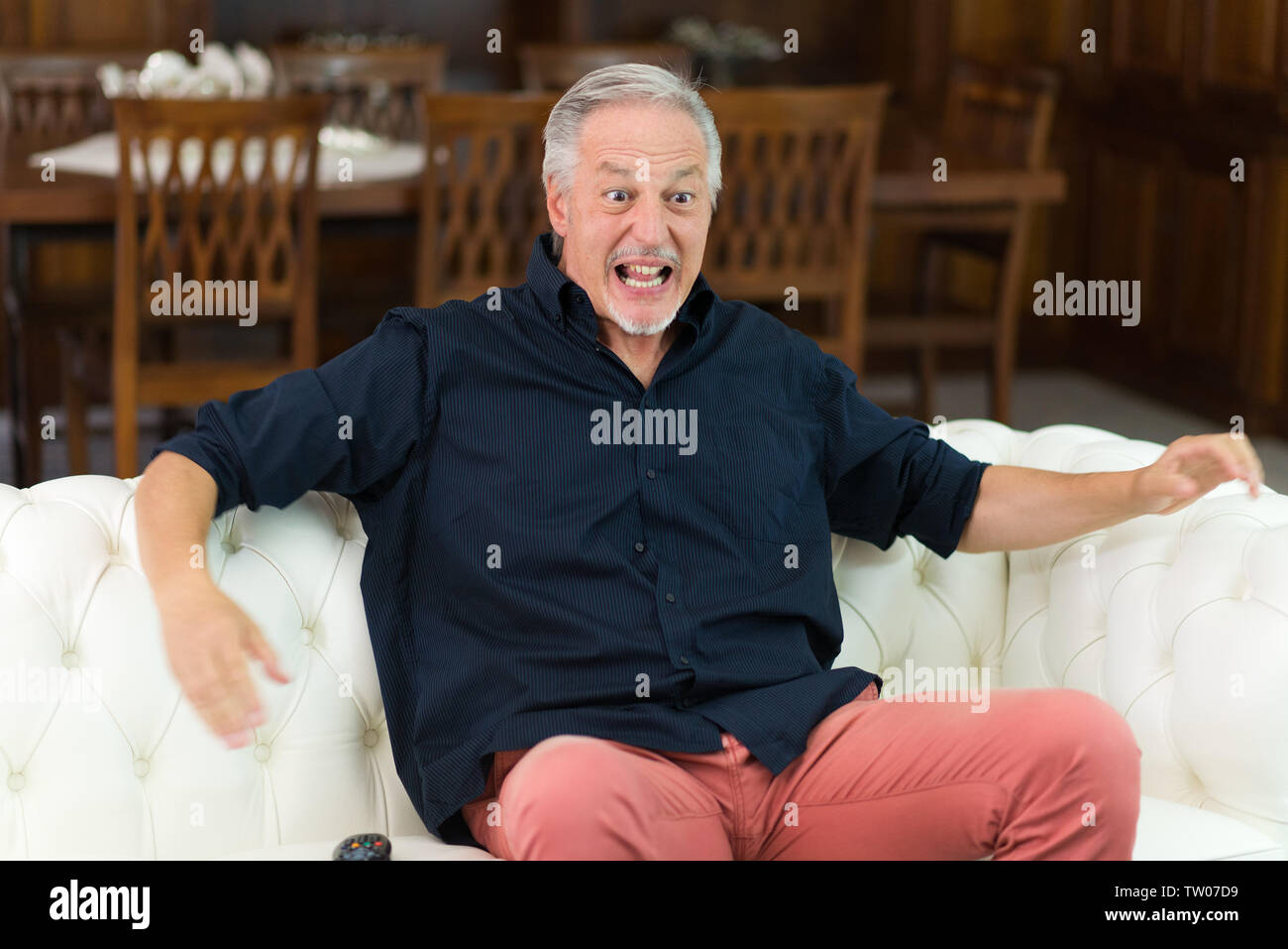 Homme qui regarde un match de sport dans sa télévision Banque D'Images