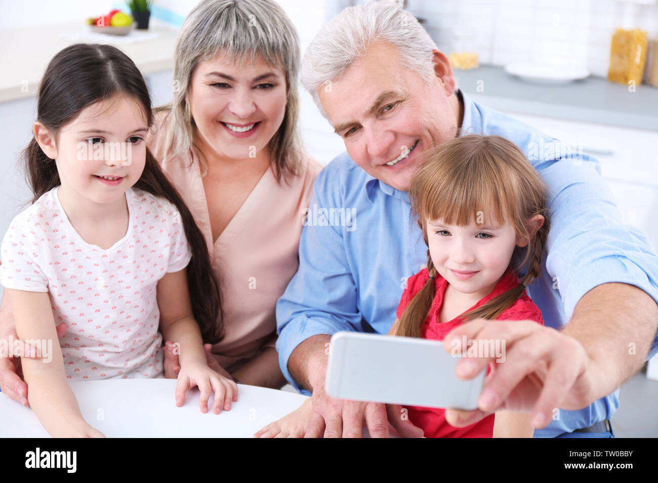 Grand parents avec peu de filles prenant selfies Banque D'Images